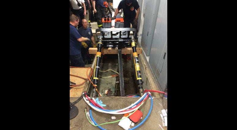 Chicago fire officials work to remove the forklift that injured a 51-year-old man Sept. 30, 2019 from a hole at the Museum of Science and Industry
