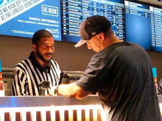 FILE - In this Sept. 5, 2019, file photo, a gambler making a sports bet at Bally's casino in Atlantic City, N.J. (AP Photo/Wayne Parry, File)