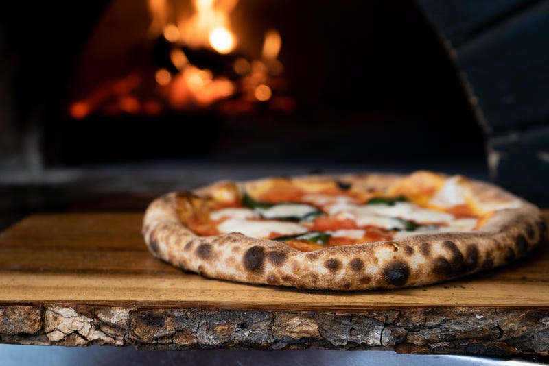 Its a Pizza in front of an oven but their pizza paddle had like bark on it its kinda weird 