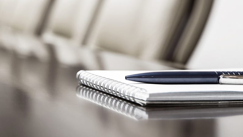 Notepad on a boardroom table - stock photo