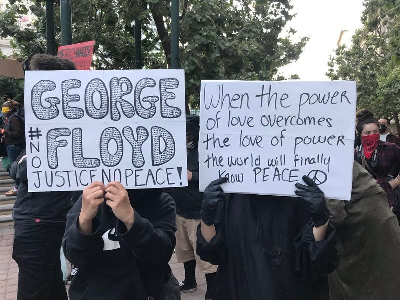 Signs held at an Oakland protest over the death of George Floyd in Minneapolis.