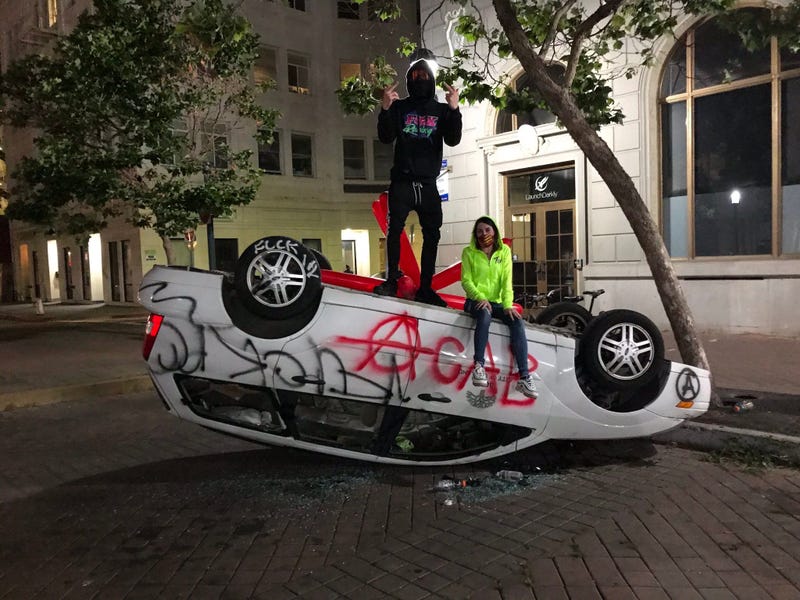 A flipped over car in downtown Oakland.