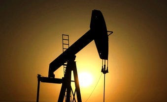 FILE- In this Wednesday, June 8, 2011 file photo, sun sets behind an oil pump in the desert oil fields of Sakhir, Bahrain. The global benchmark for crude oil rose above $70 a barrel on Monday.  (AP Photo/Hasan Jamali, File)