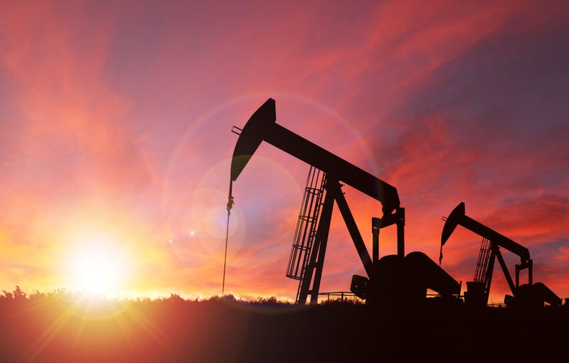 Pump jack silhouette against a sunset sky