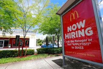 FILE - In this July 1, 2019, file photo, a help wanted sign appears on a bus stop in front of a McDonald's restaurant in Miami. (AP Photo/Wilfredo Lee, File)