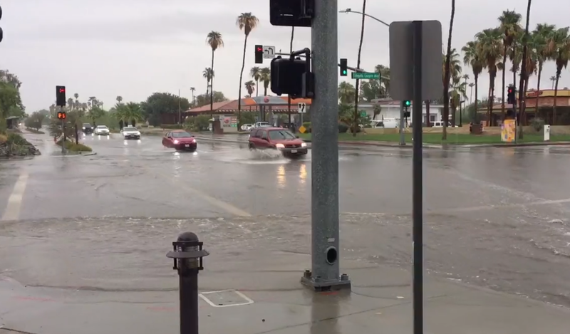 cars driving through flooded intersection