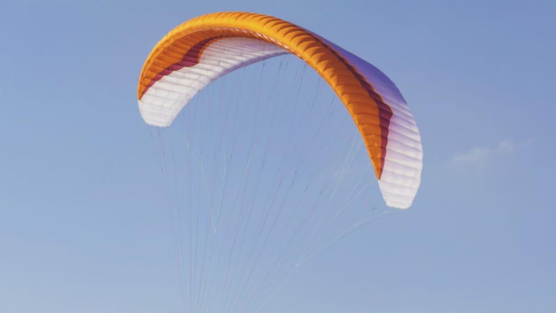 Paraglider sail on a blue sky background - stock photo
