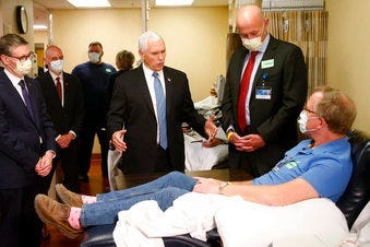 Vice President Mike Pence, center, visits Dennis Nelson, a patient who survived the coronavirus and was going to give blood, during a tour of the Mayo Clinic Tuesday, April 28, 2020. (AP Photo/Jim Mone)