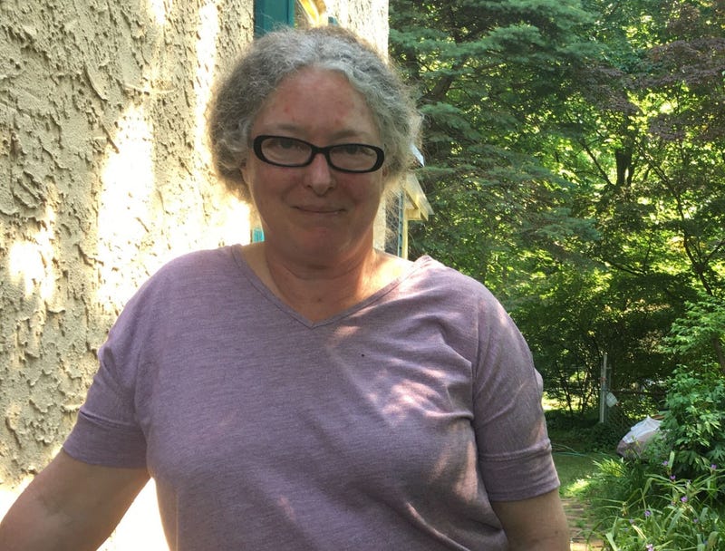 Anne Peters stands in front of her home.