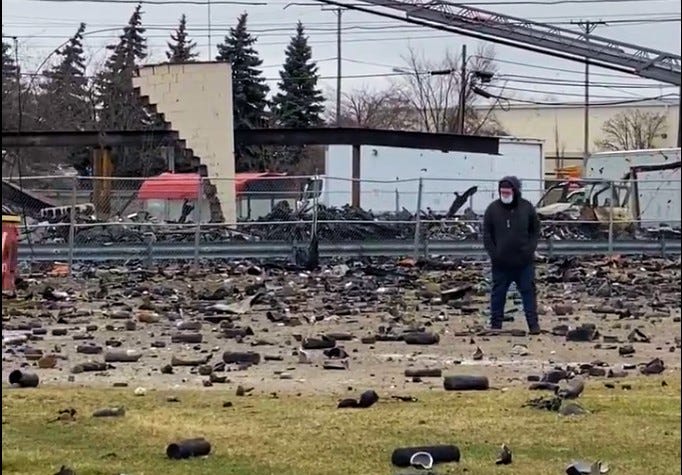 People walk around the site of Monday night's fire and explosions in Clinton Township. 