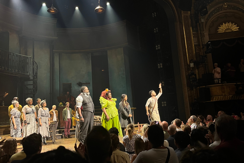 Jordan Fisher as Orpheus waves to the crowd during the closing of Hadestown, standing alongside Phillip Boykin as Hades, Maia Reficco as Eurydice, and Yolanda Quartey (Yola) as Persephone.