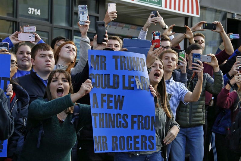 University of Pittsburgh sophomore Lynne Jaworski, from Homer City, Pa., holds a sign and yells as President Donald Trump's motorcade arrives at the University of Pittsburgh's Presbyterian Hospital.