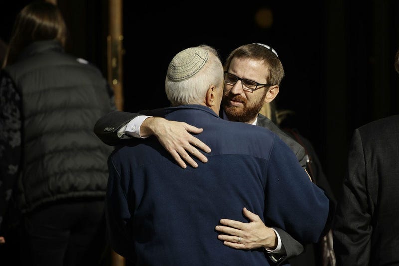 Mourners hug outside Rodef Shalom Congregation during the funeral services for brothers Cecil and David Rosenthal, Tuesday, Oct. 30, 2018, in Pittsburgh.