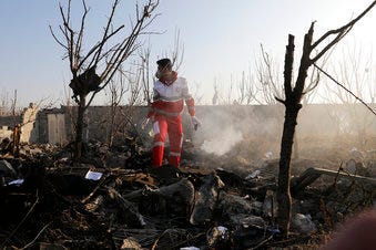 A rescue worker searches the scene where an Ukrainian plane crashed in Shahedshahr, southwest of the capital Tehran, Iran, Wednesday, Jan. 8, 2020. (AP Photo/Ebrahim Noroozi)