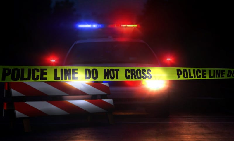 Police car at a crime scene at night with police yellow tape line