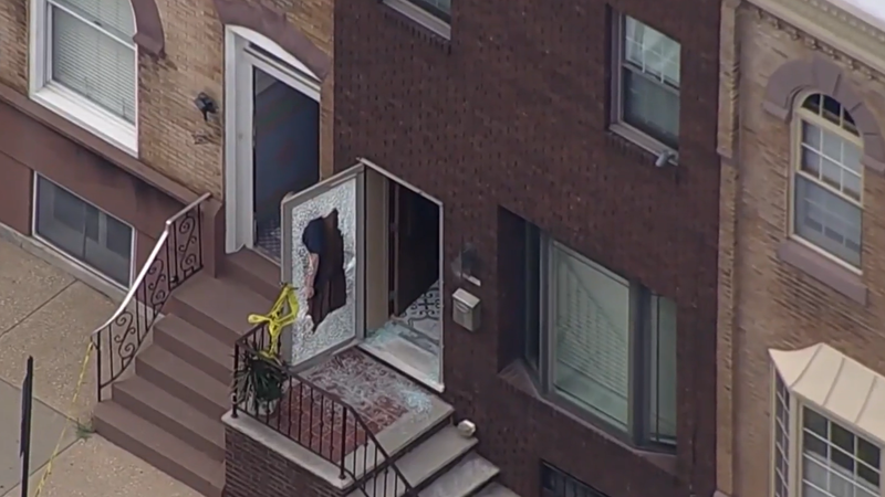 A shattered glass door following a July shooting in South Philly that wounded a 72-year-old woman and killed a dog.