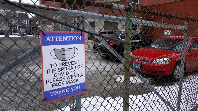 A sign on the fence outside of Lowell elementary school asks students, staff and visitors to wear a mask to prevent the spread of COVID-19 on January 05, 2022 in Chicago, Illinois.