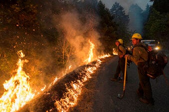FILE -Firefighters monitor a controlled burn along Nacimiento-Fergusson Road to help contain the Dolan Fire near Big Sur, Calif., Friday, Sept. 11, 2020. Ivan Gomez who started a 2020 wildfire that killed 12 endangered California condors and seriously injured a firefighter was sentenced to 24 years in state prison, prosecutors said