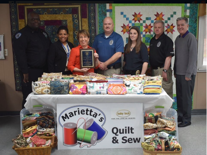 Quilt & Sew receives Chief's Award Winner of the Year.  Photo: L-R, Simpsonville PD Lt. Timmie L. Williams, Victims Advocate Milena Banquez, Quilt & Sew co-owner Marietta Louk, Chief Mike Hanshaw, Cpt. Cheryl Manley, Lt Russ Holthaus and Mayor Shewmaker