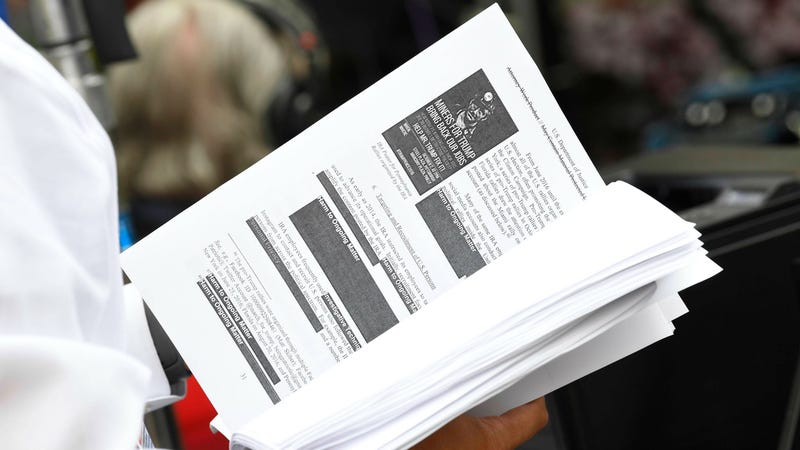 Television networks print out and read the released Mueller Report on the sidewalk outside of the Department of Justice.