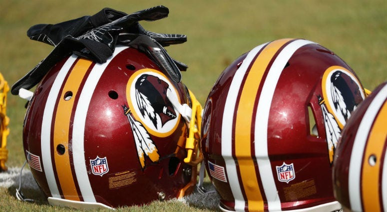 Redskins helmets sit on the field prior to practice.