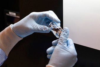 FILE - In this March 2020 photo provided by Gilead Sciences, a vial of the investigational drug remdesivir is visually inspected at a Gilead manufacturing site in the United States. (Gilead Sciences via AP)