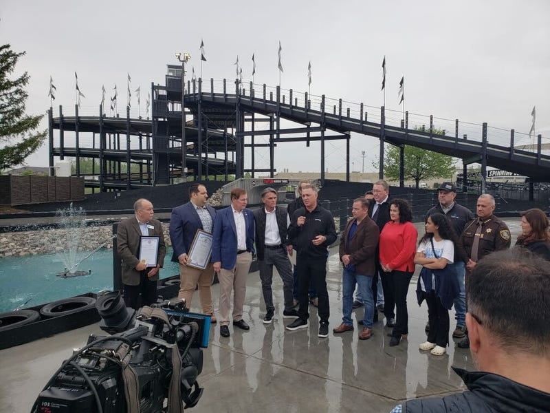 Group of people standing in front of tall GoKart track