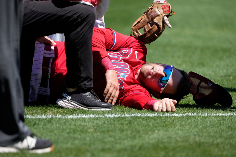 Phillies first baseman Rhys Hoskins lying on the field of Baycare Ballpark in Clearwater Florida. He was injured Thursday attempting to field a ball and subsequently was carted off the field for an MRI exam.