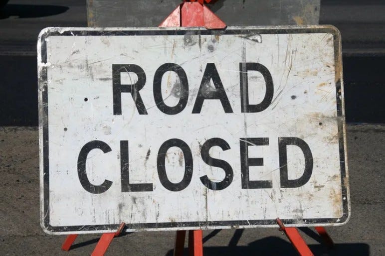 sign says road closed 