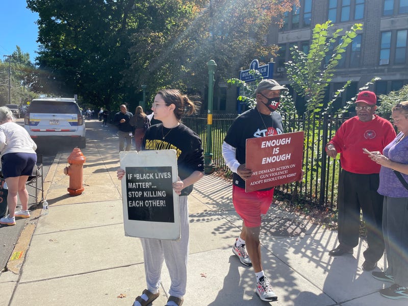 Community members carried signs outside Roxborough High Wednesday in a protest organized by anti-gun violence advocate Jamal Johnson.