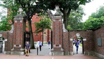 FILE - In this Aug. 13, 2019, file photo, pedestrians walk through the gates of Harvard Yard at Harvard University in Cambridge, Mass. (AP Photo/Charles Krupa, File)