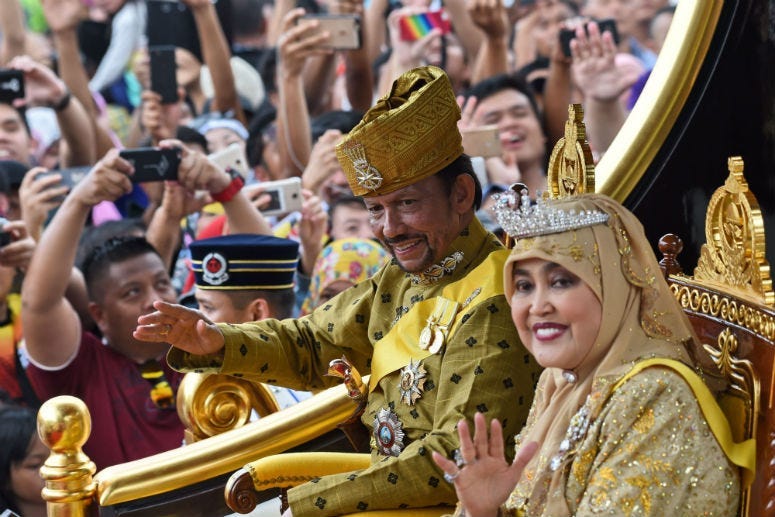 Brunei's Sultan Hassanal Bolkiah and Queen Saleha ride in a royal chariot during a procession to mark his golden jubilee of accession to the throne in Bandar Seri Begawan. 