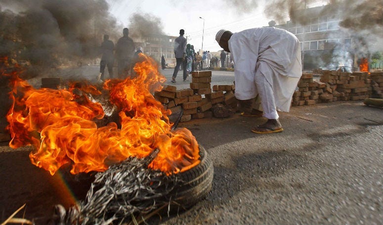 Sudanese protesters block a street with bricks and burning tires as military forces attempted to disperse the ongoing sit-in outside Khartoum's army headquarters on Monday, June 3.