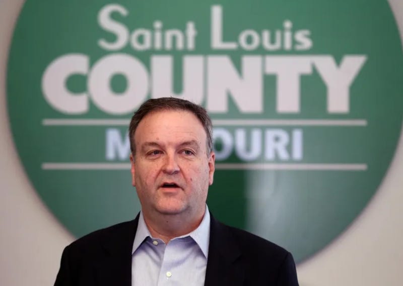 Sam Page stands in front of a green sign