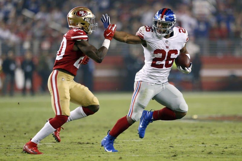 Saquon Barkley stiff arms a 49ers defender