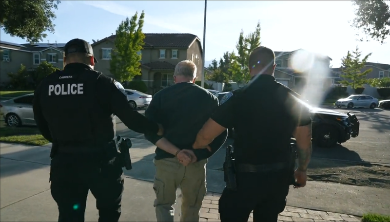 man being led to police car