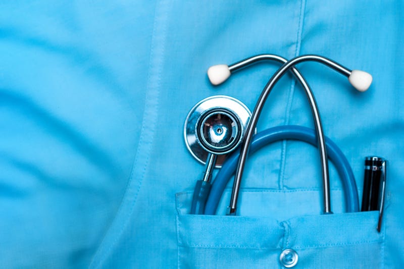 Stethoscope and pen in doctor robe pocket