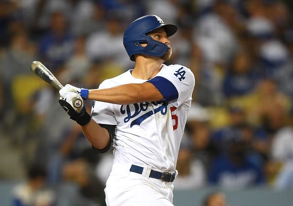 Corey Seager watches as he hits a ball deep into the outfield. 