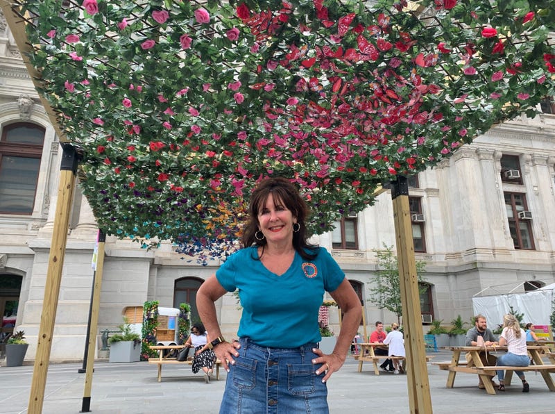The Center City District's Michelle Shannon underneath a floral pergola.