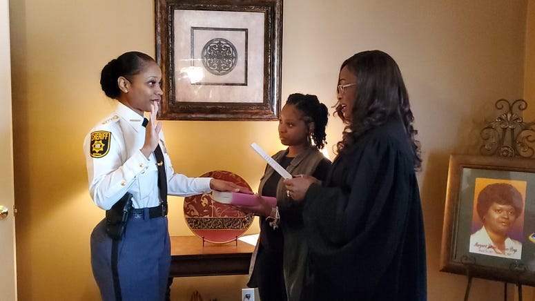 Melody Maddox is sworn in as sheriff by DeKalb Superior Court Judge LaTisha Dear Jackson as Maddox's daughter Indira Woodward looks on