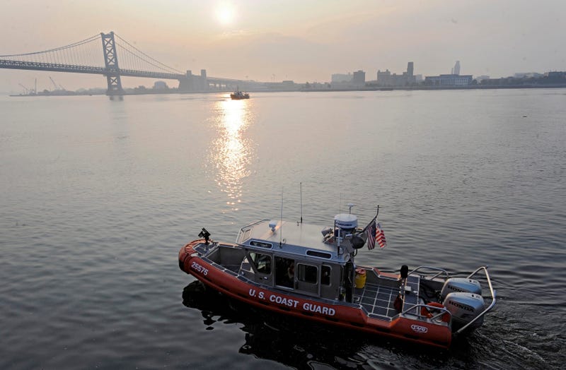 A U.S. Coast Guard boat cruises the Delaware River at Penn's Landing.