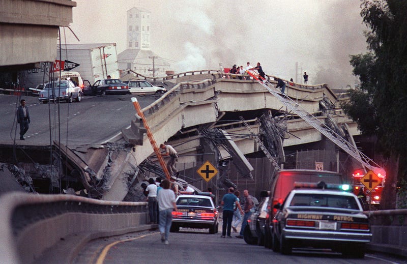 Rescue workers and police enter the scene of destruction where the Interstate 880-Interstate 80 interchange collapsed in Oakland during the Loma Prieta earthquake in October 1989.