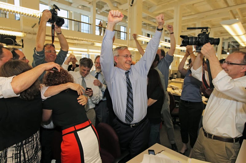 Members of the Philadelphia Inquirer staff react to learning of their Pulitzer Prize for Public Service from their series on School Violence, Monday, April 16, 2012. Editor Stan Wischnowski, center, raises his hands in celebration.