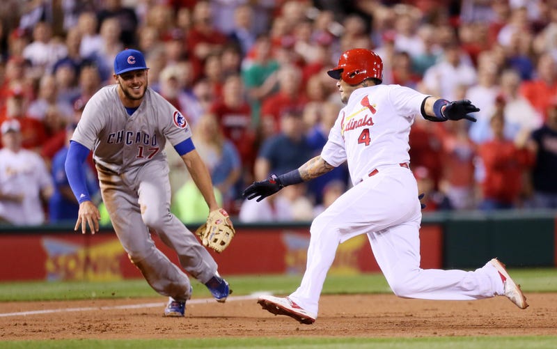 St. Louis Cardinals' Yadier Molina (4) slides safely into third base with an RBI triple ahead of Chicago Cubs third baseman Kris Bryant