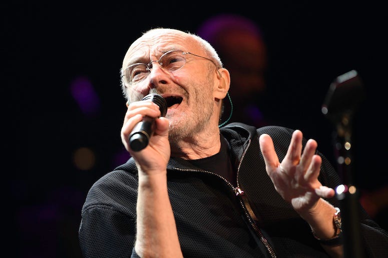 Phil Collins Falls Backwards On Stage During Concert