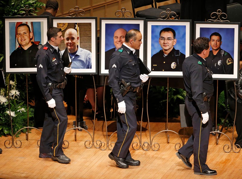 File Photo: Members of the Dallas Police Department Choir walk past portraits of their fallen comrades during a memorial for five Dallas and DART police officers shot to death in last week's attack on Tuesday, July 12, 2016