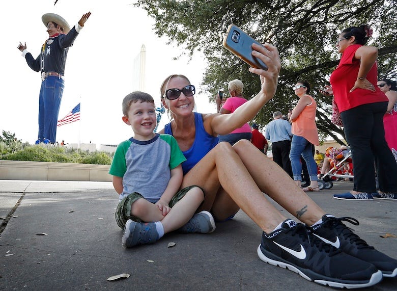 Woman and child taking a selfie with Big Tex at the State Fair of Texas