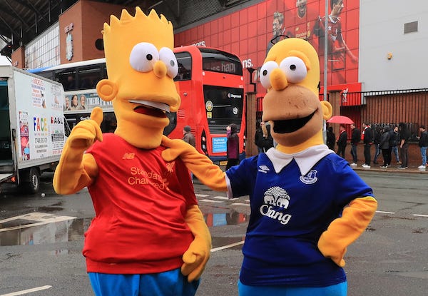 Fans dressed as Bart and Homer Simpson before the Premier League match at Anfield, Liverpool