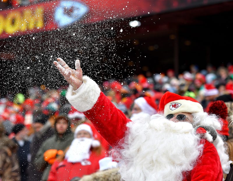 A KC Chiefs fan dressed as Santa throws snow