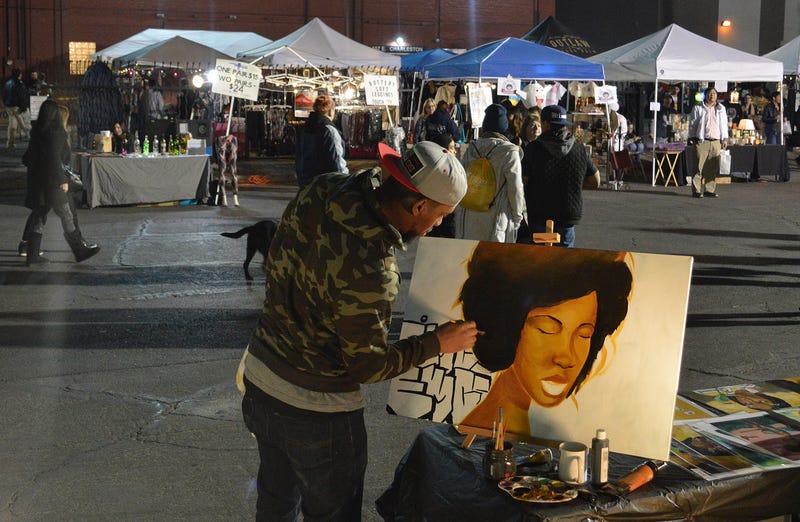 An artist works on a new piece live, amidst the buzz of First Friday, a street festival that takes over the Arts District once a month